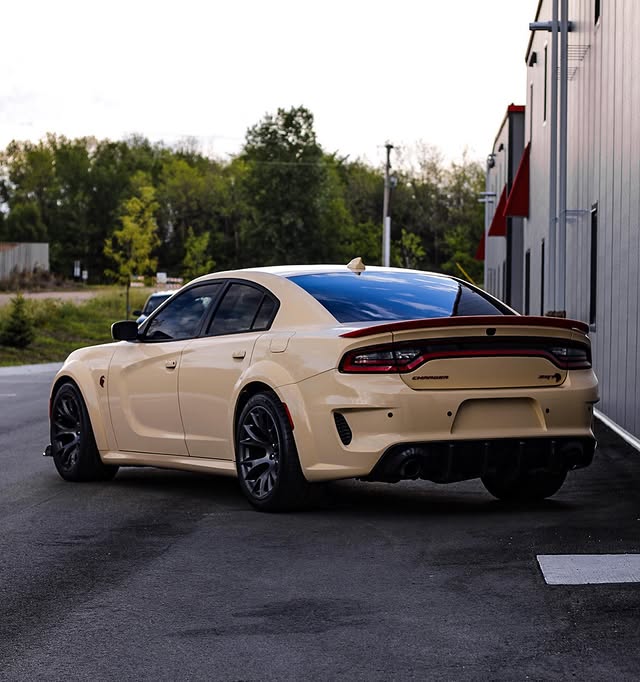 A tan Dodge Charger SRT parked outside the Chanhassen shop after service