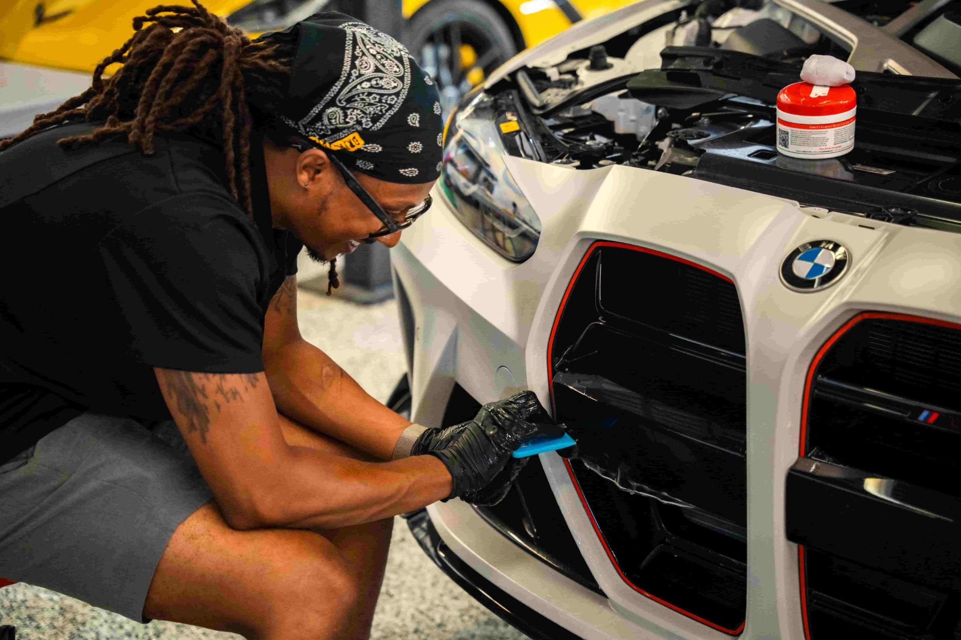 Detail work around the grille of a white BMW in the Midwest Auto Pros bay